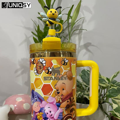 Stanley tumbler in yellow Bee Bear theme displayed next to decorative gift box.
